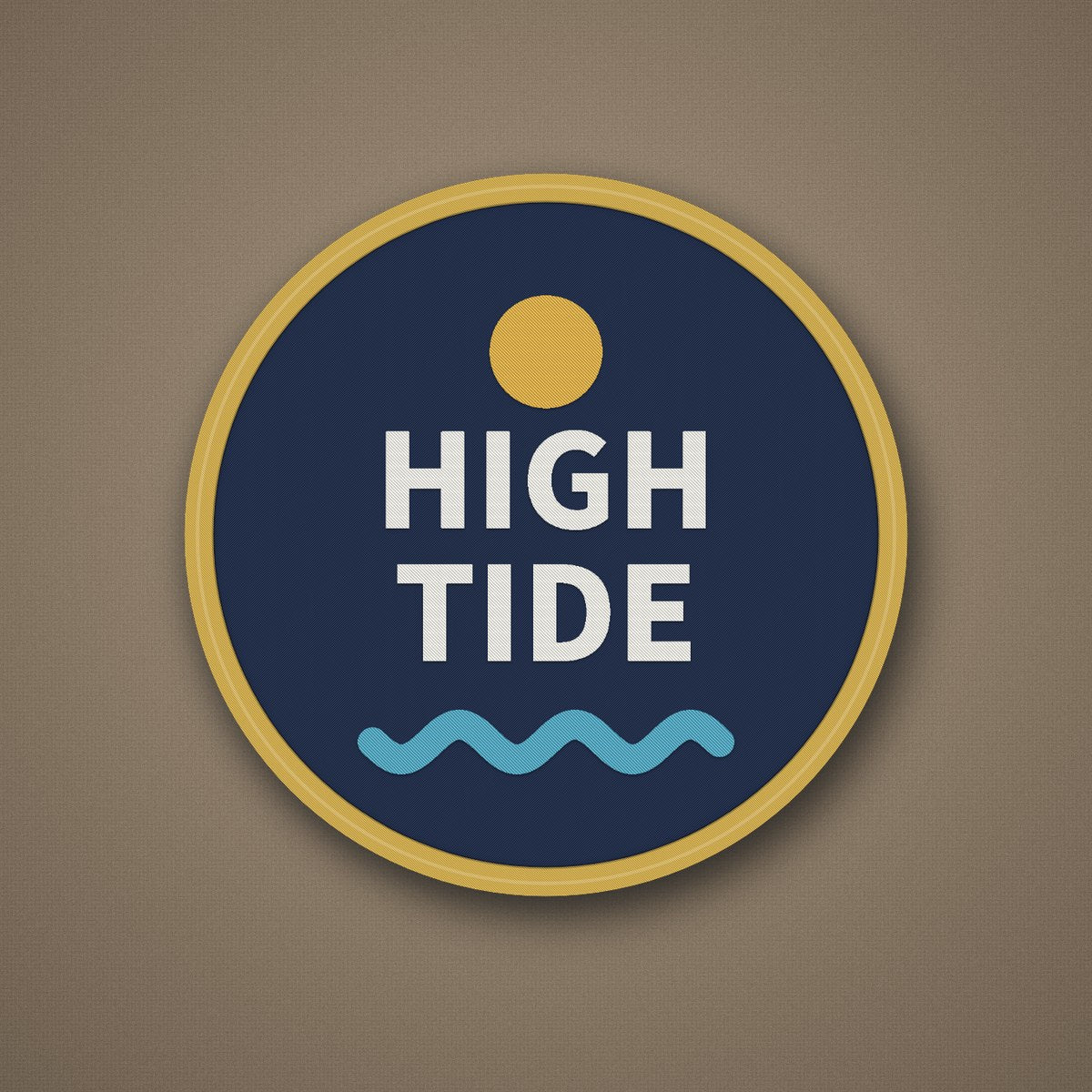 Example embroidered patch: round navy twill patch with a gold merrowed border and a stitched sun, HIGH TIDE lettering and wave